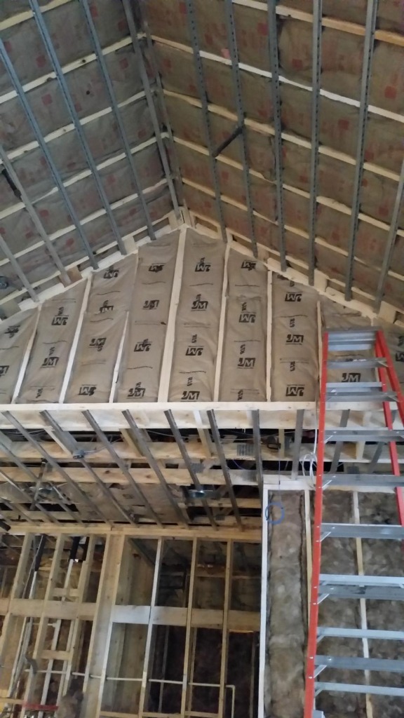 Fiberglass batt insulation installed between wall studs and roof rafters